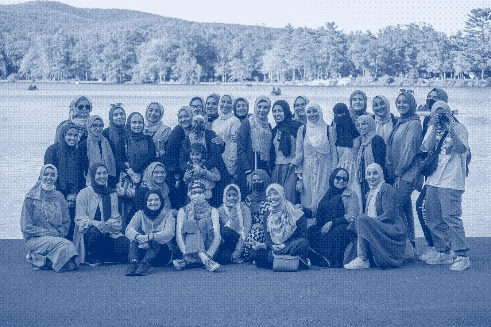 A group of women in hijab beside a lake